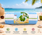 A rolled beach towel with blue and white stripes and a cartoon coconut character on the label, placed on a sandy beach with ocean and palm trees in the background. The image includes promotional text and feature icons for the towel.