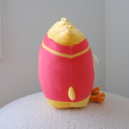 A plush toy shaped like french fries, shown from the side while sitting on a textured white surface against a plain light gray wall.